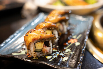 Grilled eel sushi on black plate. Japanese food.
