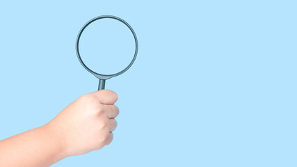 Fototapeta na wymiar magnifying glass in hand isolated on blue background