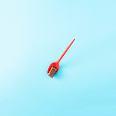 Red spoon decorative with chocolate an a blue background.