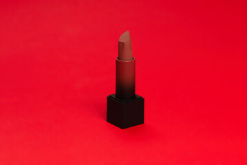 Red lipstick on a red background. Makeup.