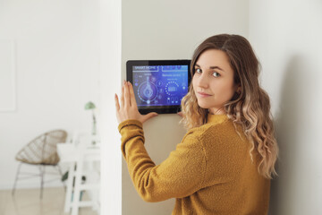 Woman using smart home security system control panel