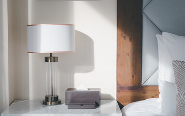 A bedside lamp that shines in the morning sunlight into the bedroom.