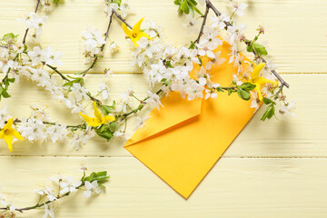 Beautiful blooming branches and envelope on color background