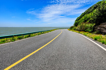 Asphalt highway and mountain with blue sea natural landscape.