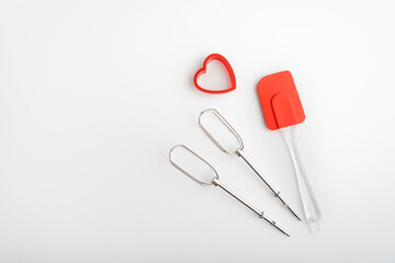 Mixer whisk, kitchen silicone spatula and cookie cutter on white background.