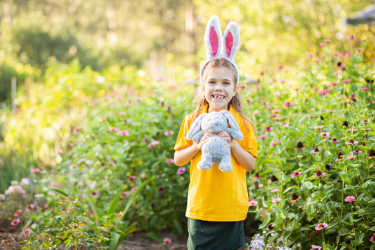 Happy school girl ready for Easter with plush bunny rabbit and ears