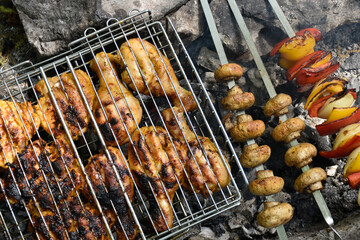 Grilled meat and vegetables. Delicious chicken with golden crust, grilled mushrooms, bell peppers and onions skewers.