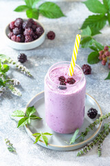 Natural healthy detox, fruit dessert, healthy dieting concept. Blackberry milk shake or Yogurt smoothie in glass jar on a light stone tabletop.