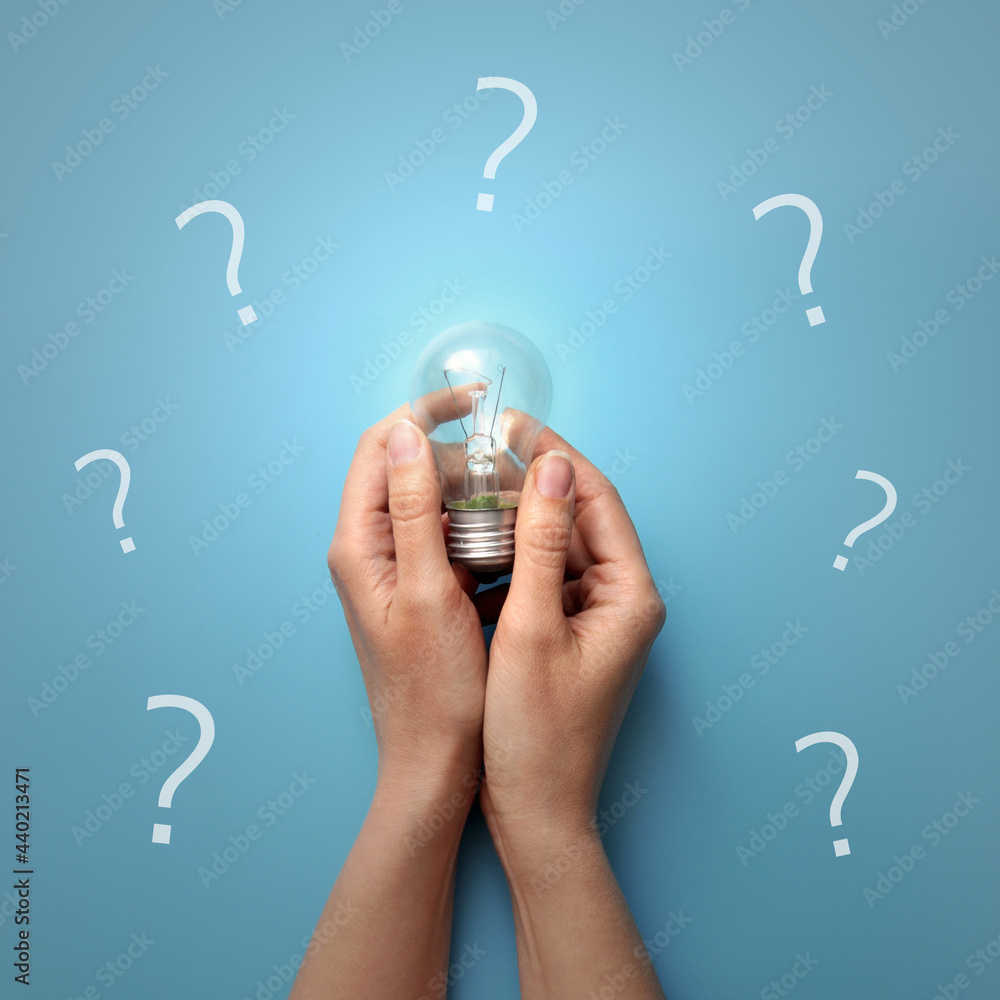 Poster a burning lamp in his hands, surrounded by question marks. the emergence of the idea of solving a co
