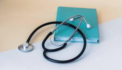 Green diary and medical stethoscope on a white background. Top view with copy space for text or any design.