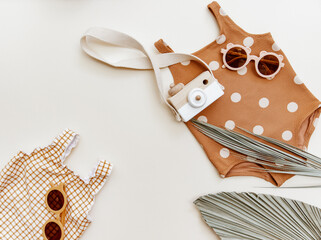 Two retro swimsuit for child with sunglasses on neutral beige background. Summer holiday concept