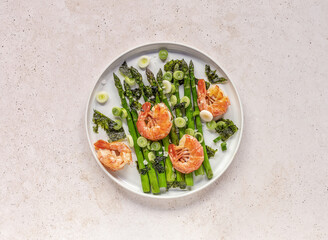Seasonal salad from prawn shrimp, green asparagus, onion, and seaweed on a plate. Clean healthy eating.
