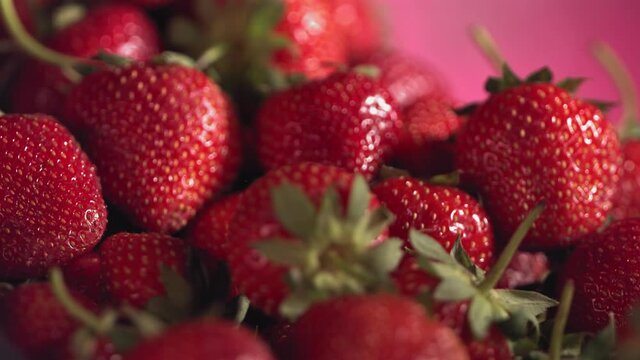 Ripe juicy Strawberry is rolling above many strawberries