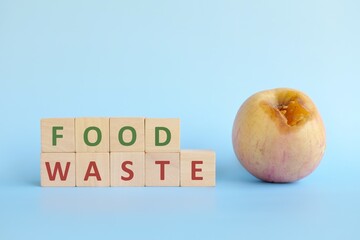 Food waste concept. Fruit and vegetable scrap with wooden blocks typography in blue background with copy space.
