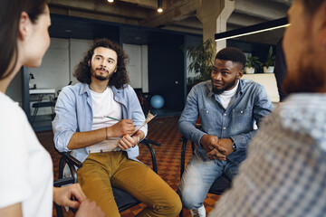 Young people sitting in a circle and having a discussion