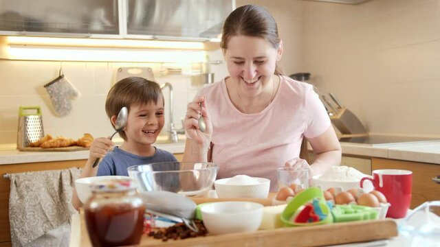 Little boy with mother looking on ingredients for cooking tasty dish. Children cooking with parents, little chef, family having time together, domestic kitchen.