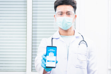 Doctor man in medical mask show app smartphone mobile digital vaccinated passport coronavirus (COVID-19) certificate to confirm, vaccine health pass concept