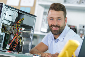 smiling young electronics technician at work