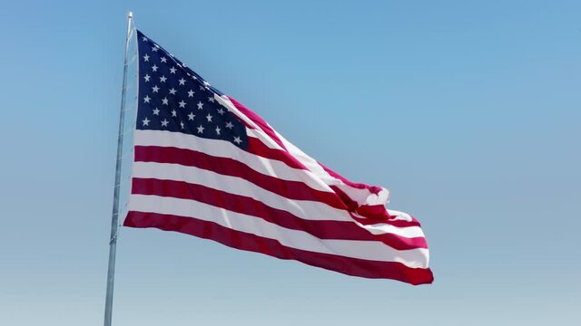 USA American Flag 4K. Slow motion American Flag blowing in blue sky background