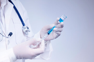 Fototapeta premium Doctor holds syringe and coronavirus vaccine bottle,concept of corona virus treatment