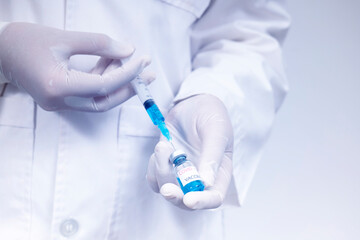 Doctor holds syringe and coronavirus vaccine bottle,concept of corona virus treatment