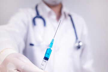 Close up doctor hand holding syringe with were surgical mask and gloves