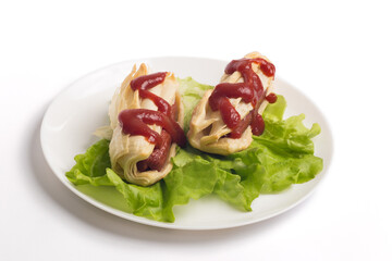 two appetizing sausages in a dough on a white plate with fresh lettuce leaves, parsley and ketchup
