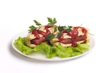 two appetizing sausages in a dough on a white plate with fresh lettuce leaves, parsley and ketchup