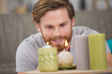 young man litting candle at home