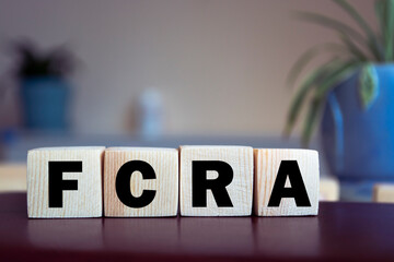 FCRA - Fair Credit Reporting Act, word written on wooden blocks on wooden table. Concept for your...