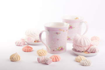 A few sweet meringues and tender marshmallows around cups with fragrant cocoa