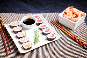 Fototapeta na wymiar Plate with sushi, bowl with shrimp and bowl of soy sauce. Asian food. Healthy food concept