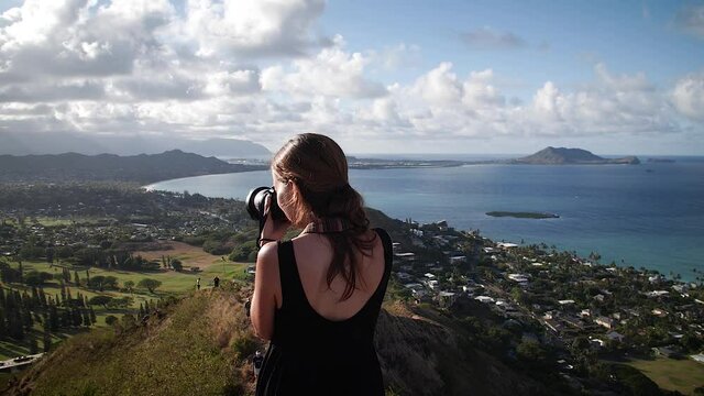 Woman photographing landscape at sunset from Pillbox in Lanikai beach, Oahu, Hawaii. Mid angle, parallax movement, slow motion, HD.