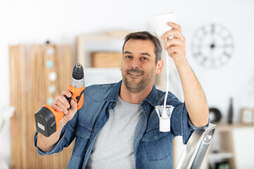 man is drilling the ceiling to place a lamp