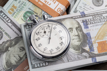 Money and stopwatch. Dollars banknotes and stopwatch. Time is money