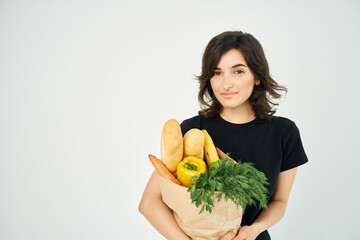 woman with a package of groceries shopping delivery to vegetables