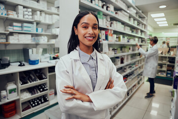 Portrait of young african american pharmacist standing between aisle in chemist with colleague...