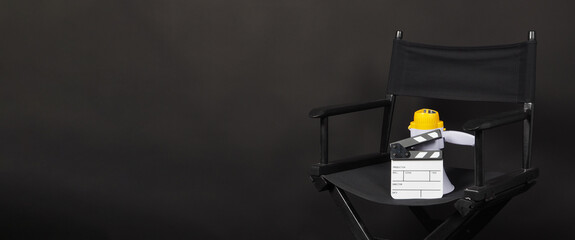BLACK director chair with Clapperboard or movie Clapper board and megaphone on black background.it use in video production or film and cinema industry.