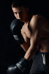 Fototapeta na wymiar boxer leaned forward on black background with gloves 