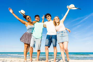 Group of multiracial young tourists posing for portrait photography in summer at tropical sea ocean...