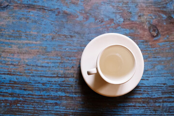 Empty coffee cup on a blue painted wooden background.