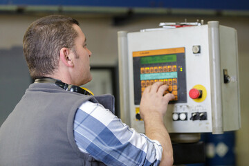 Fototapeta na wymiar factory worker operating machine units in workshop
