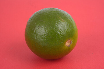 Citron vert en gros plan sur fond rouge