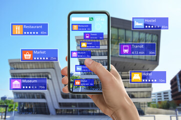 Tourist using online guide application on smartphone for navigation in city, closeup. Augmented...