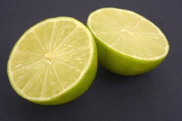 Citron vert coupé en deux en gros plan sur fond noir