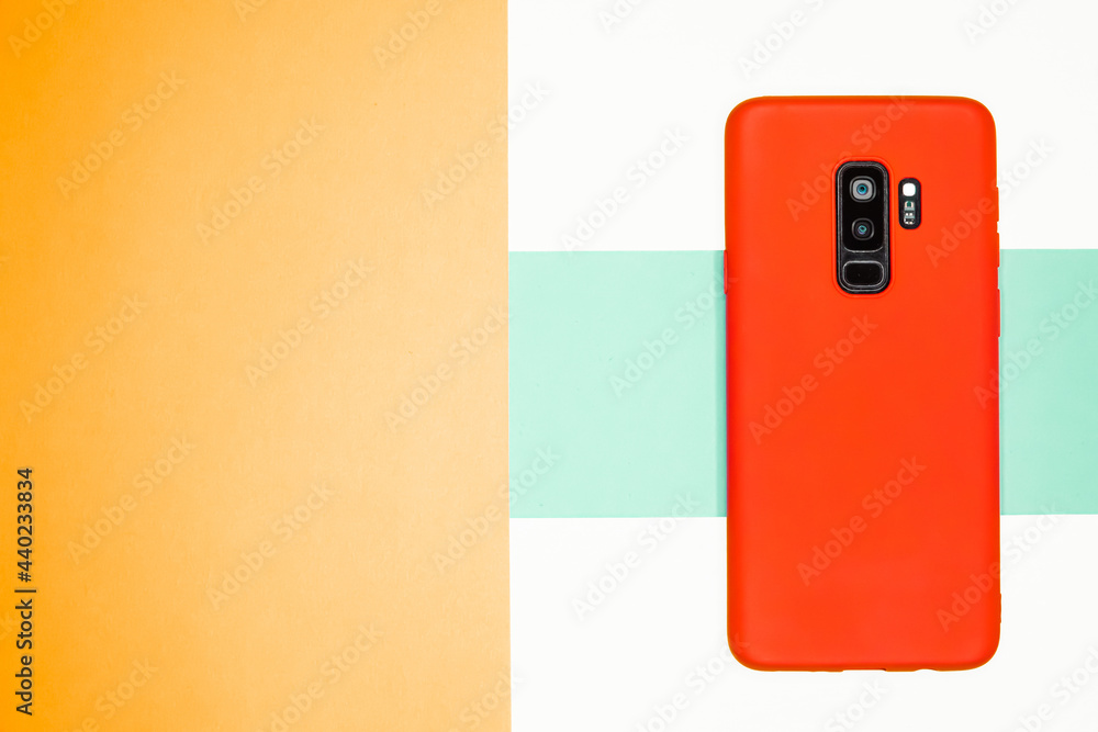 Poster top view of a phone with a red case on a colorful background