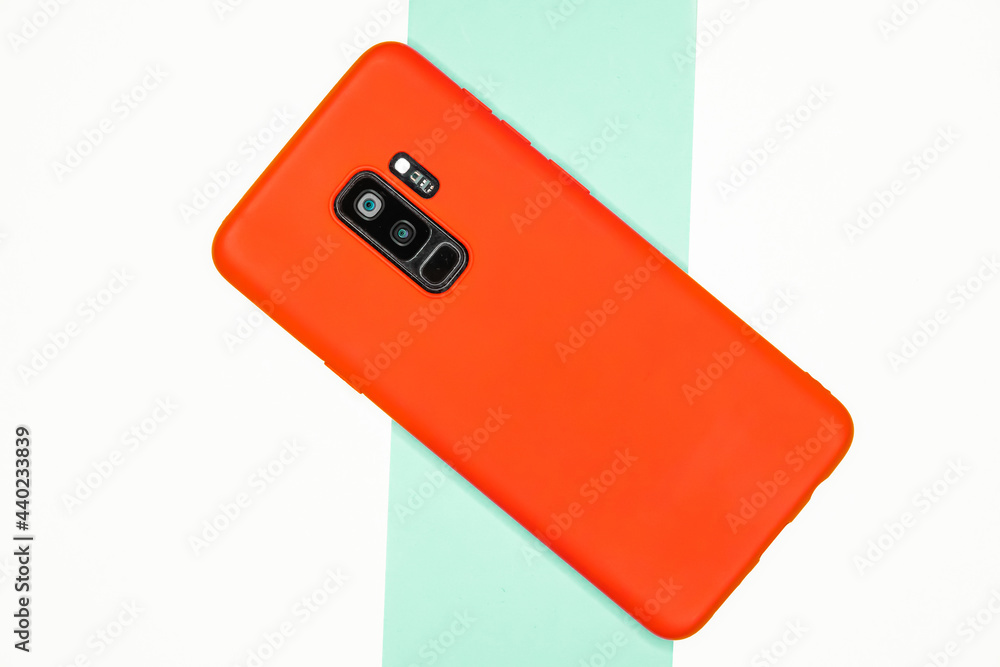 Poster top view of a phone with a red case on a striped background