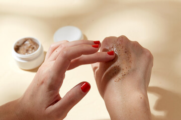 beauty, cosmetics and object concept - close up of hands applying natural body scrub to skin on...