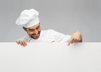 cooking, culinary and people concept - happy smiling male chef in toque with big white board over...