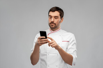 cooking, culinary and people concept - male chef with smartphone over grey background